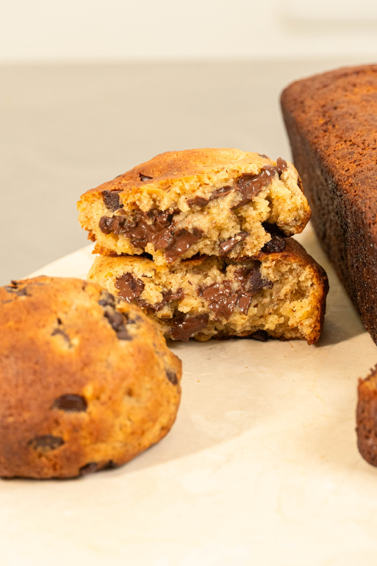Cookie de chocolate sin gluten partida junto a un banana bread saludable