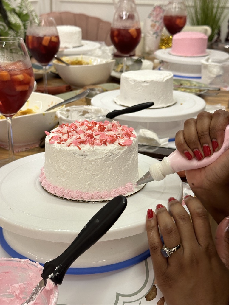 Participante decorando su mini bizcocho en un Sip and Cake